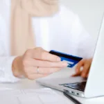 person in white long sleeve shirt holding credit card