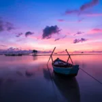 blue and white boat on body of water