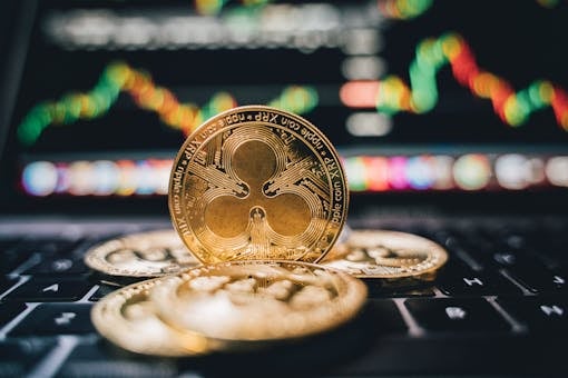 Golden Ripple XRP coins on laptop, symbolizing cryptocurrency trends and online trading.