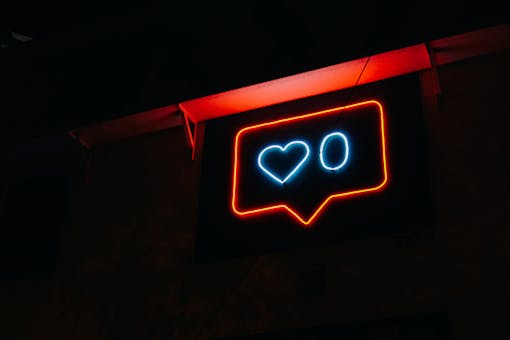 Bright neon heart icon with zero likes, symbolizing social media engagement.