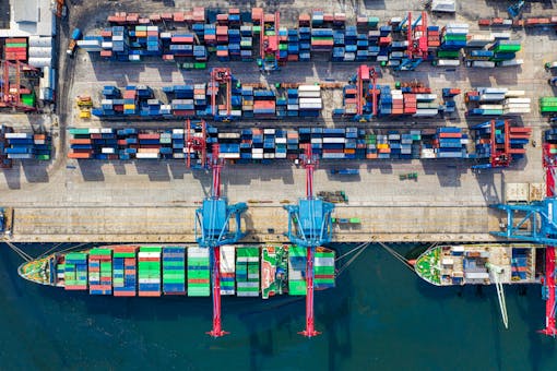 Drone shot capturing vibrant container ships and dock in North Jakarta port, Indonesia.