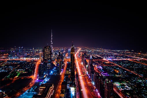 A breathtaking aerial view of Dubai's cityscape at night, highlighting the illuminated Burj Khalifa and surrounding skyscrapers.