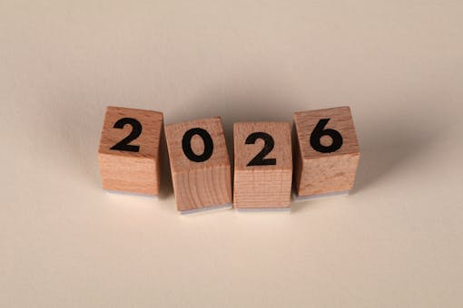 Wooden cubes forming the year 2026 on a neutral background.